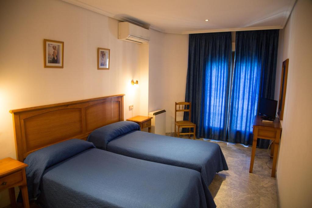 ein Hotelzimmer mit 2 Betten und einem Fenster in der Unterkunft Hostal Acuario in Gálvez