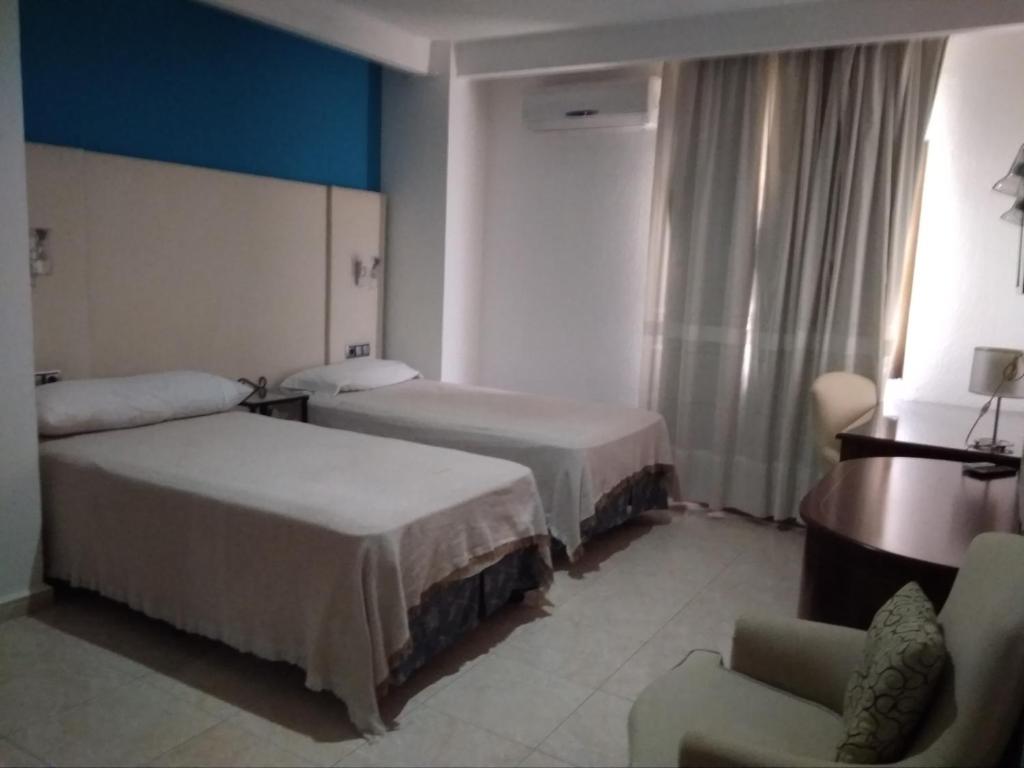 Posteľ alebo postele v izbe v ubytovaní Hotel Nuevo Ara