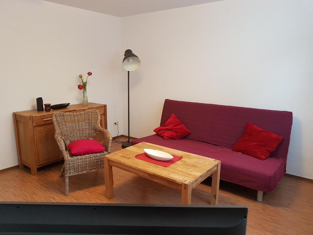 ein Wohnzimmer mit einem lila Sofa und einem Tisch in der Unterkunft 25 Schützenstraße in Diekholzen