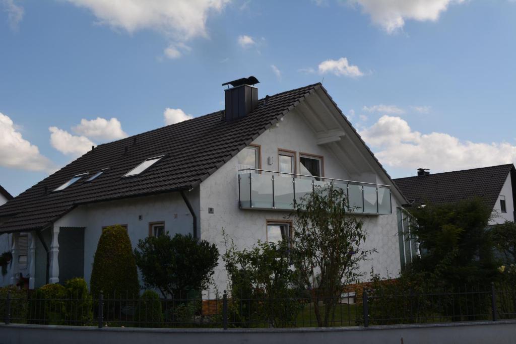 uma casa branca com um telhado preto em Ferienwohnung Margit em Deiningen