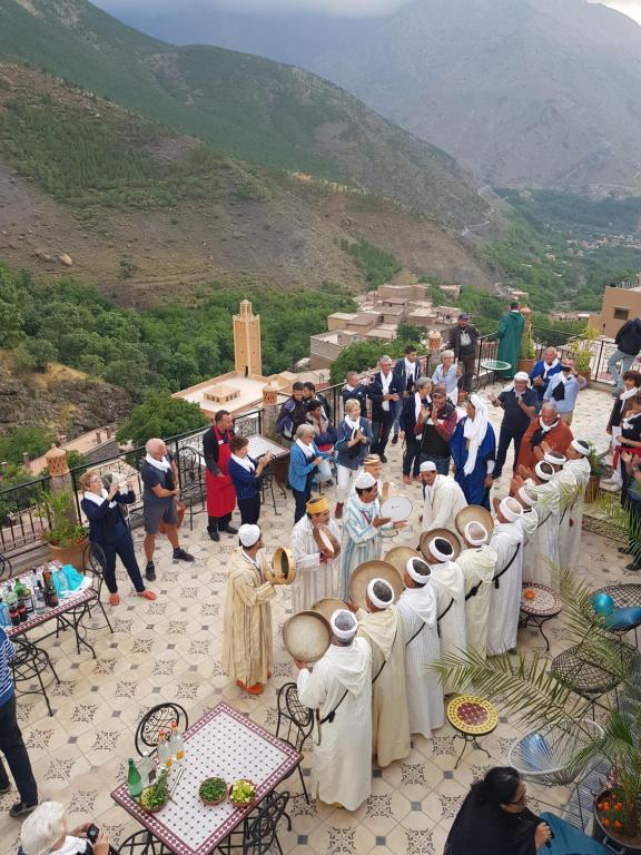 a group of people dressed in white standing on a mountain at Toubkal Garden in Imlil