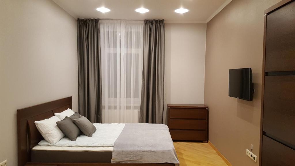 リヴィウにあるSoprano Apartment Tamanskaのベッドルーム(枕付きベッド1台、テレビ付)