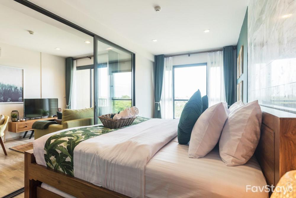 - une chambre avec un grand lit et une grande fenêtre dans l'établissement Rain Cha-am Huahin Tropical style, à Phetchaburi