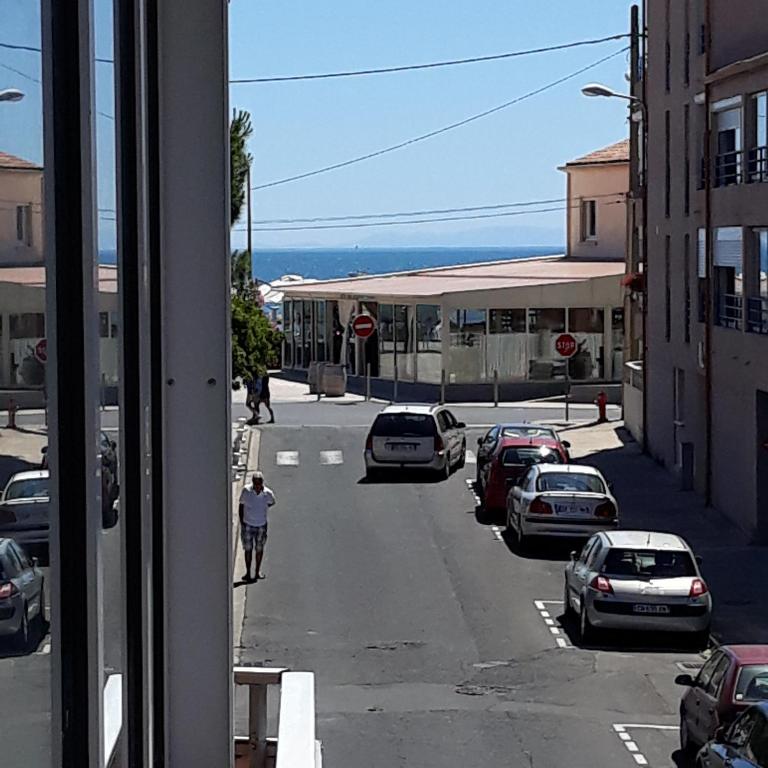 - une vue depuis la fenêtre d'une rue avec des voitures garées dans l'établissement location en bord de mer grau agde, au Grau-dʼAgde