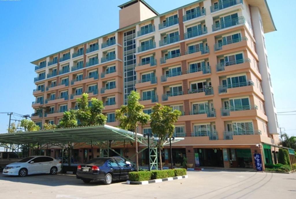 a large building with cars parked in a parking lot at Green Residence Ayutthaya - SHA Certified in Phra Nakhon Si Ayutthaya