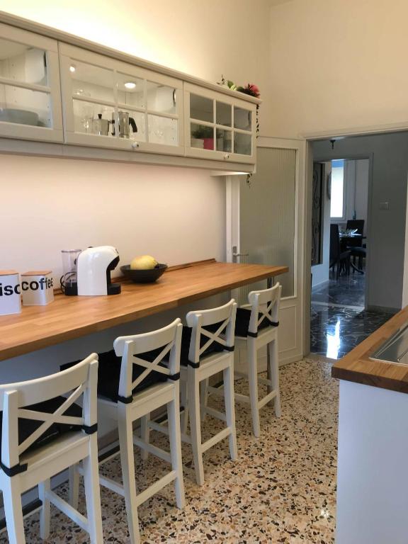una cocina con encimera y taburetes blancos en Cozy Apartment Sabrina, en Signa