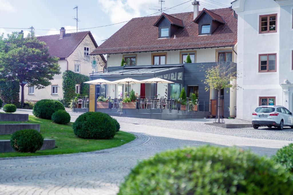 une maison avec une voiture garée devant elle dans l'établissement Gasthaus und Pension Zur Linde, à Rot an der Rot