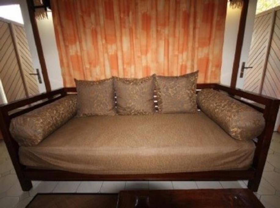 a couch with pillows on top of a room at Appartement à la Résidence LA PLANTATION RESORT and SPA in Saint-François