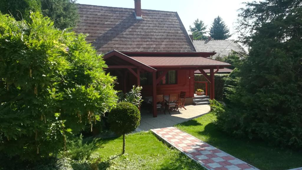 Cette cabane en rondins dispose d'une terrasse couverte et de chaises dans la cour. dans l'établissement Kéri Apartman, à Mosonmagyaróvár