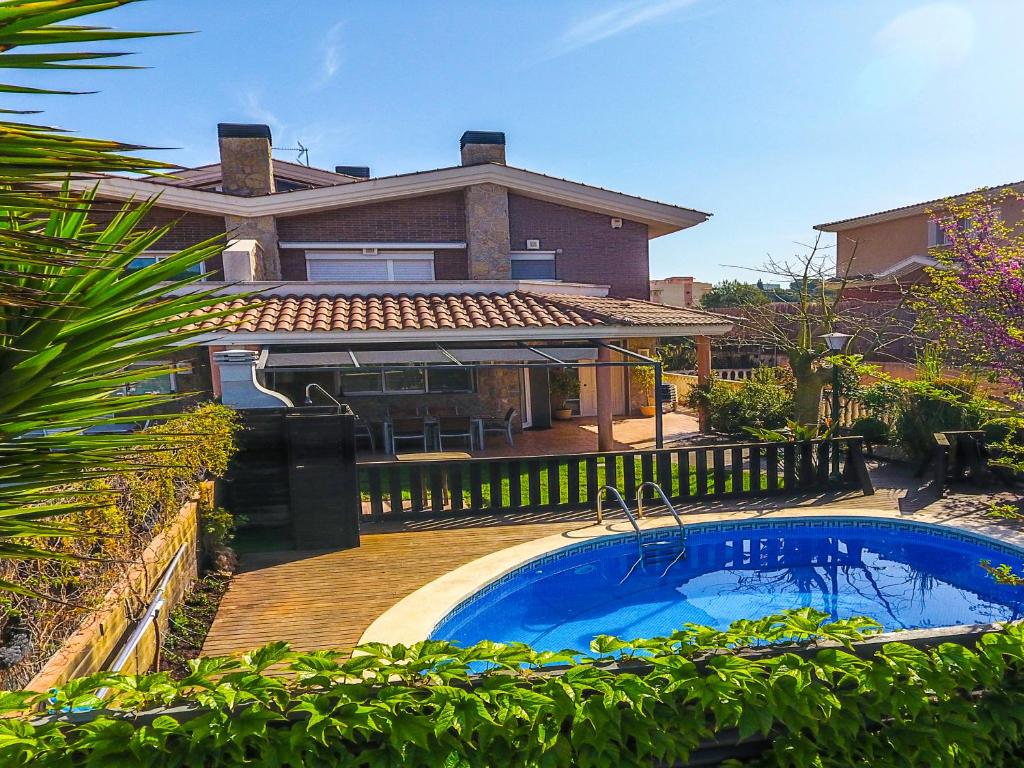 a house with a swimming pool in front of a house at Alojamiento Villa Moles in Salou