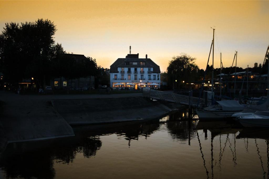 ein großes weißes Gebäude neben einem Wasserkörper in der Unterkunft Hotel Schiff am See in Konstanz