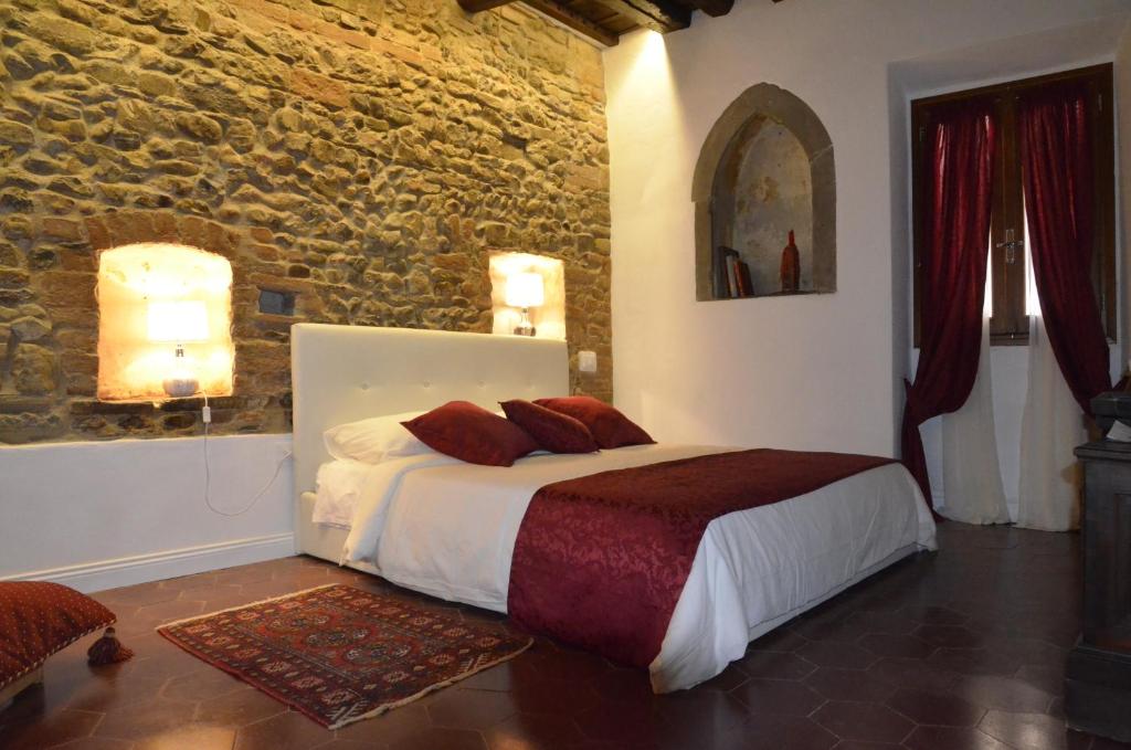 a bedroom with a bed and a stone wall at Suite la Nicchia Guelfa in Florence