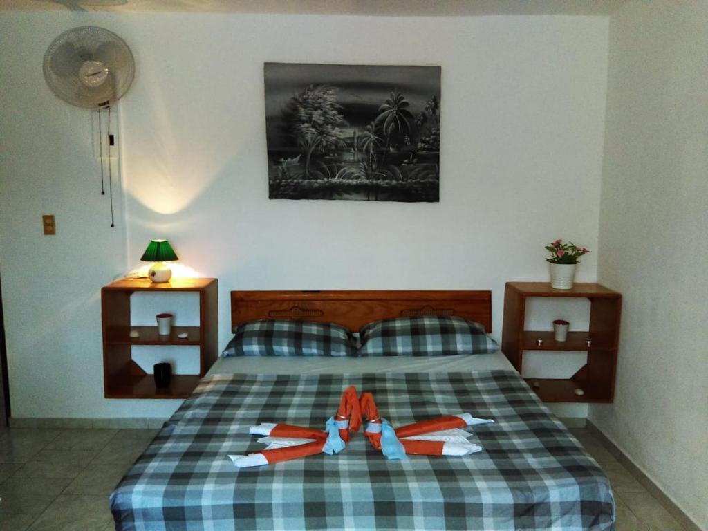 Un dormitorio con una cama con toallas rojas y blancas. en Casa Picadilly, en Boca Chica