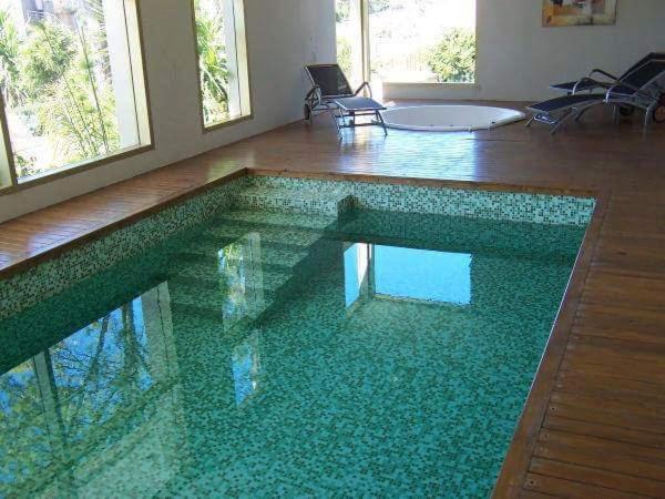 a swimming pool in a house with a green floor at Building Albar in Pinamar