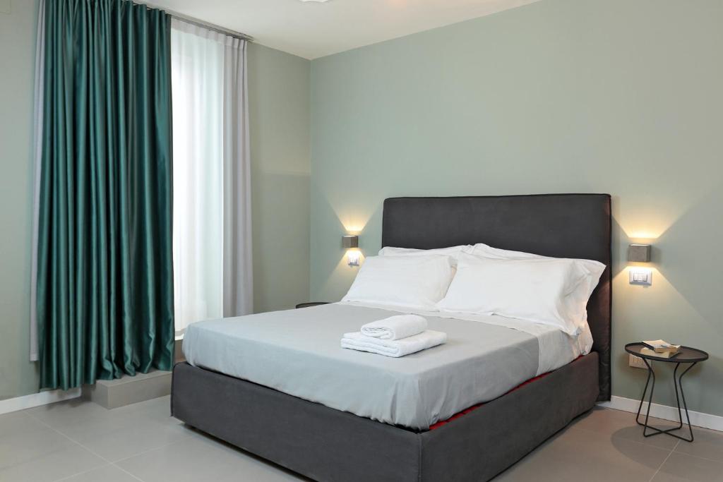 a bedroom with a large bed with green curtains at B&Bari, via Cairoli in Bari