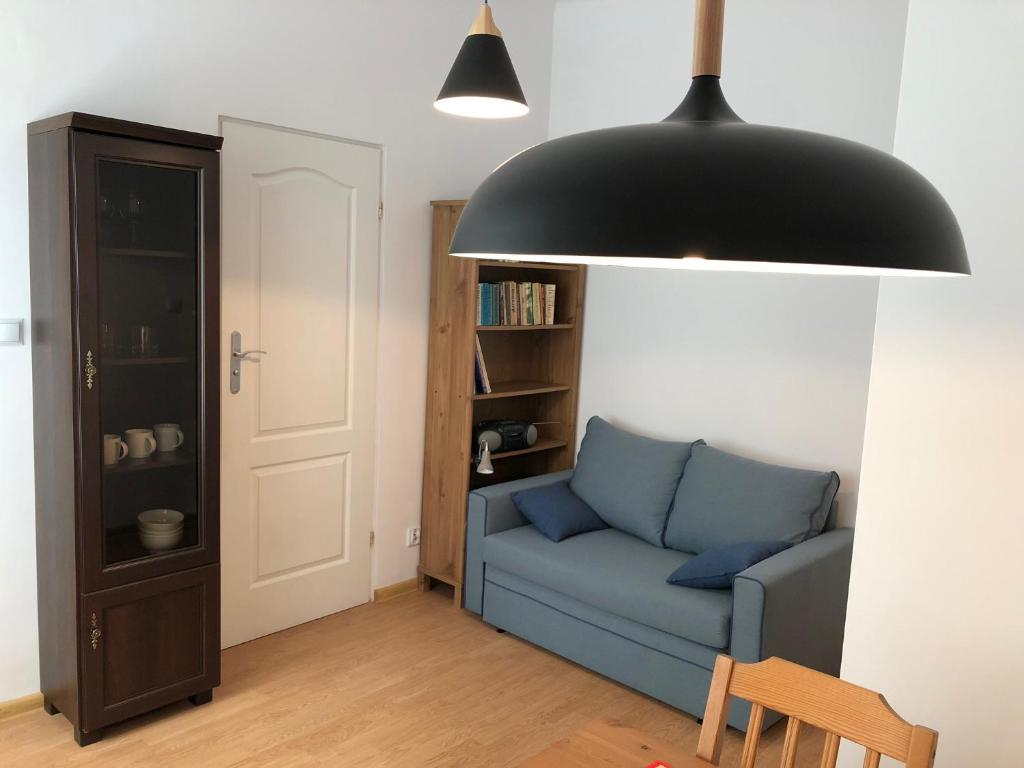 un soggiorno con divano blu e lampada a luce nera di Pulawska Nr 1 a Varsavia