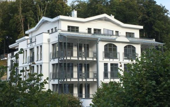 - un bâtiment blanc avec des balcons sur le côté dans l'établissement Villa Louisa - Liegestuhl 45, à Sellin