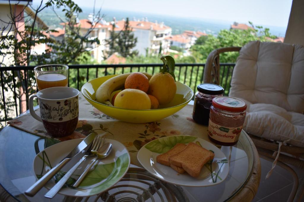 a table with a bowl of bread and a bowl of fruit at Small apartment, great view! in Veria