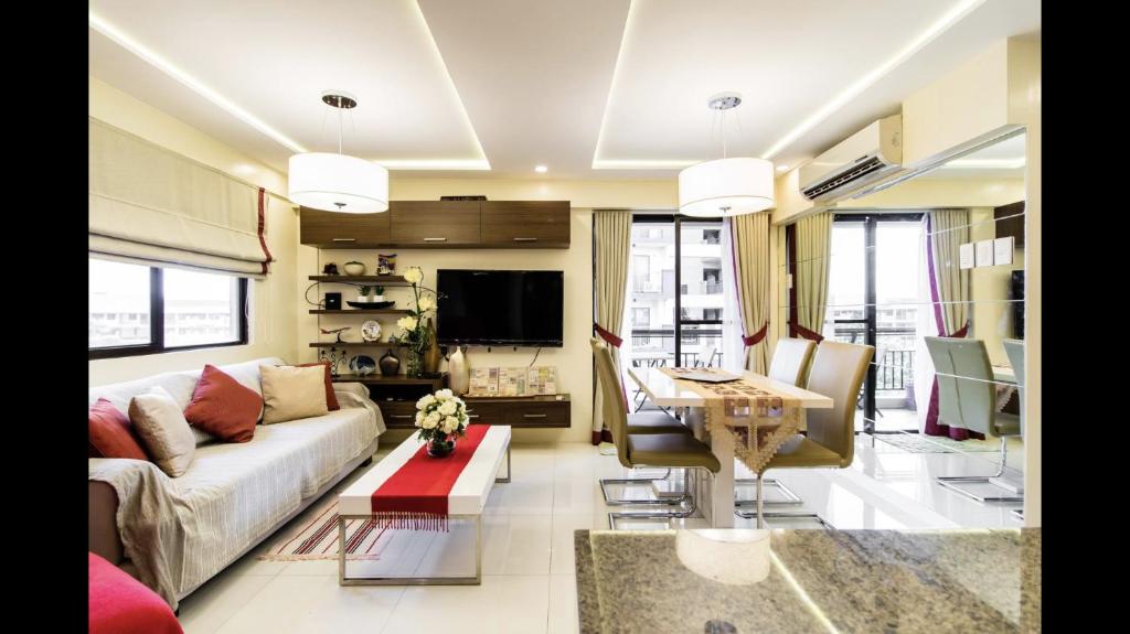 マニラにあるGrand Apartment near BGCのソファとテーブルのあるリビングルーム