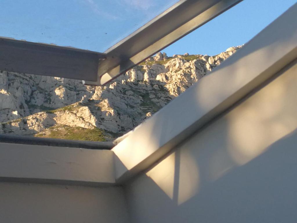 uma vista de uma janela de uma montanha em petite maison dans le parc national des calanques em Marselha