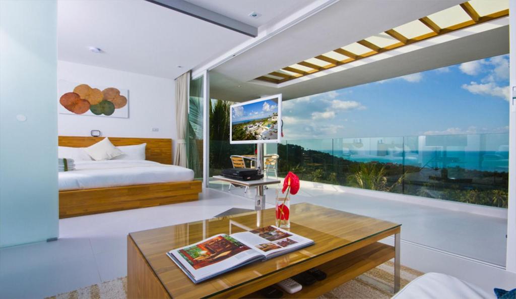 a bedroom with a bed and a table at Code Samui Hotel in Mae Nam