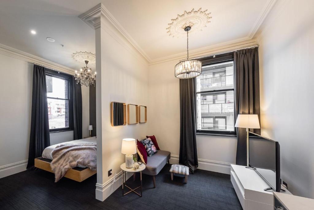 sypialnia z łóżkiem, krzesłem i oknami w obiekcie East Brunswick Hotel w Melbourne