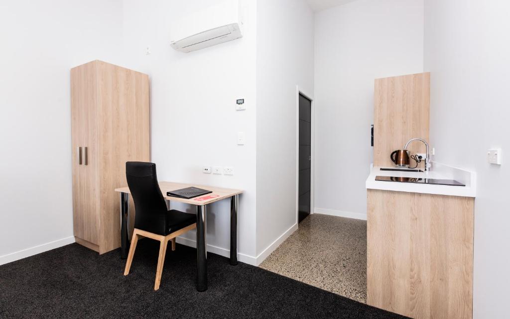 a room with a desk and a chair and a kitchen at Zachary's Motel in Levin
