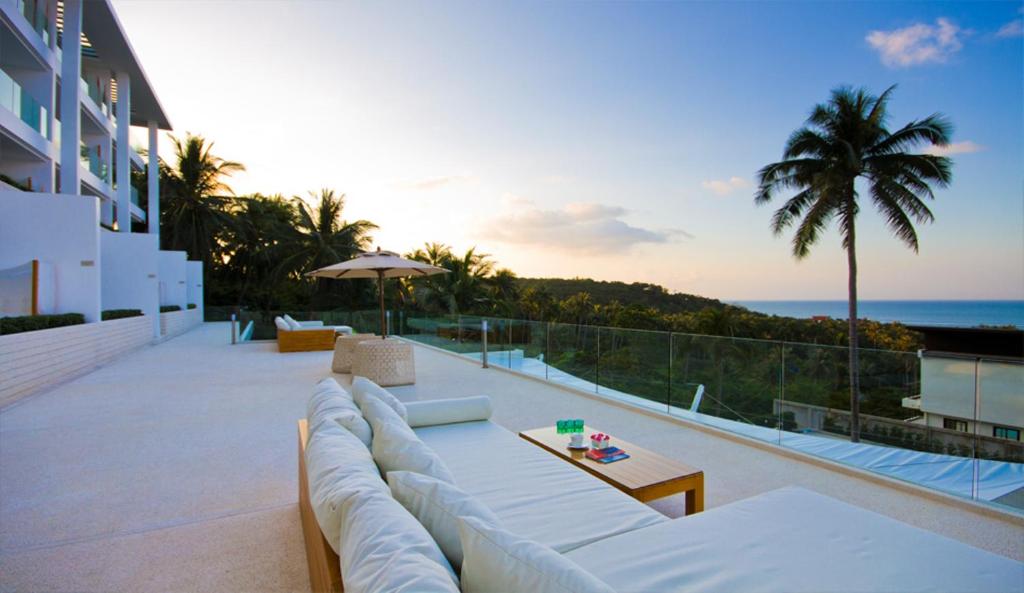a white couch on a balcony with the ocean at Code Samui Hotel in Mae Nam