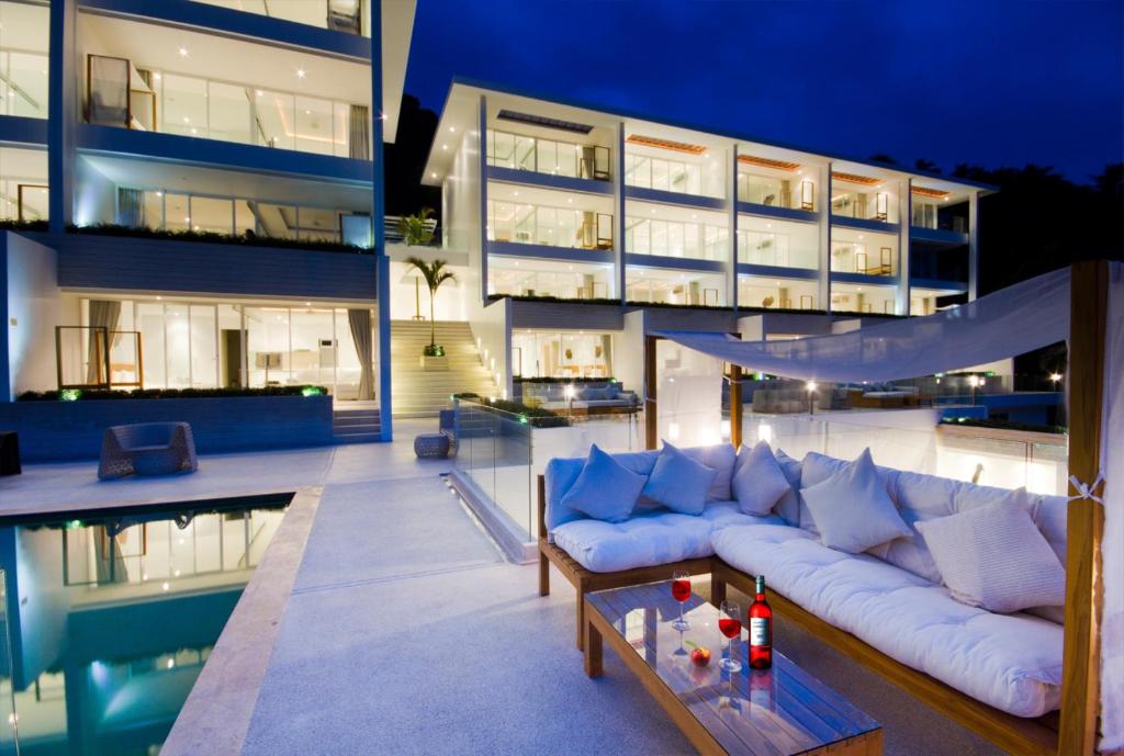 a living room with a couch in front of a building at Code Samui Hotel in Mae Nam