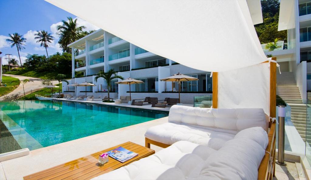 a living room with a couch and a pool at Code Samui Hotel in Mae Nam