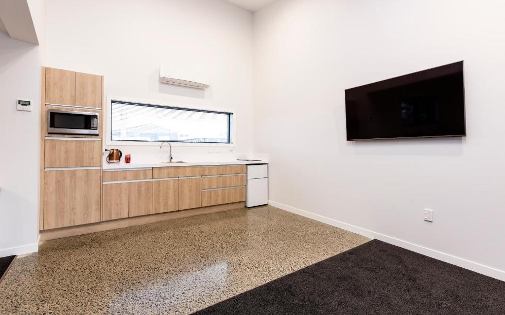 a kitchen with a sink and a tv on a wall at Zachary's Motel in Levin
