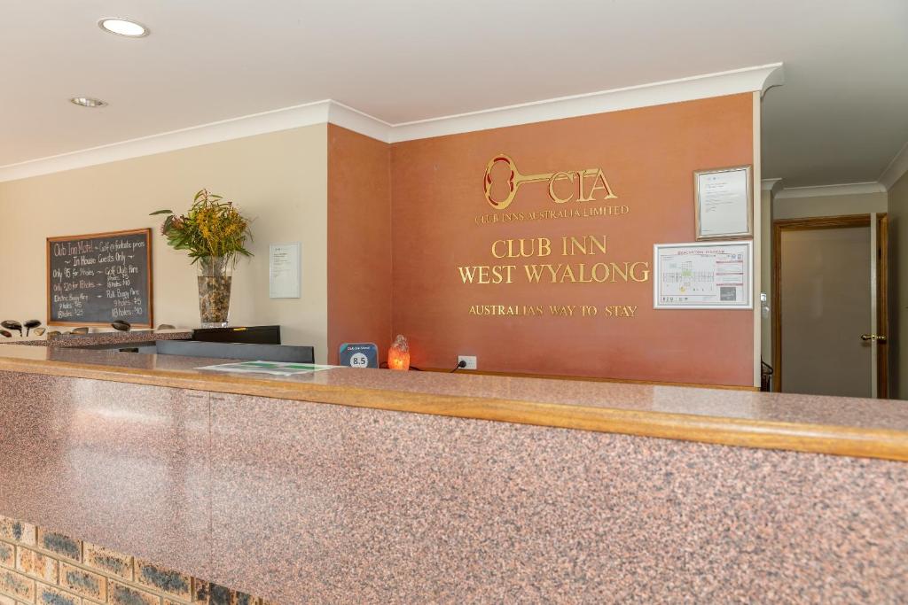 a bar in a restaurant with a sign on the wall at Club Inn Motel in West Wyalong