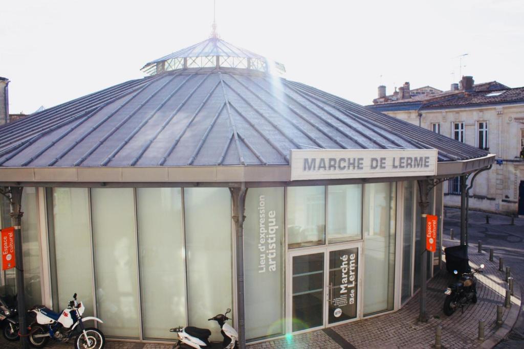 a building with a sign for a market of learning at Appartement De Lerme in Bordeaux