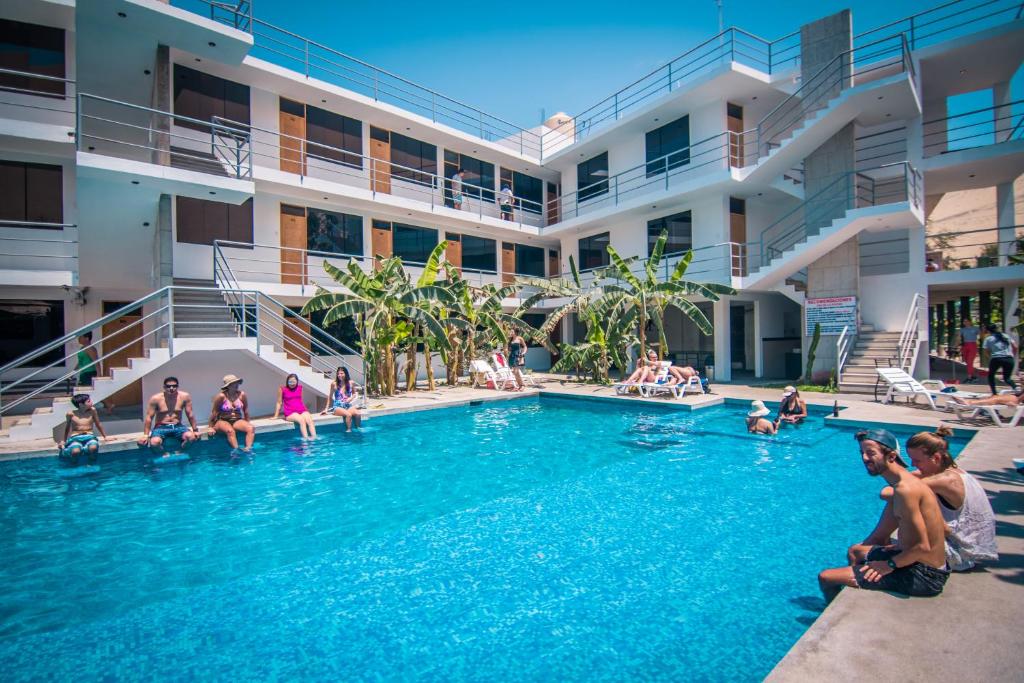 un groupe de personnes assises dans la piscine d'un hôtel dans l'établissement Carola Lodge, à Ica