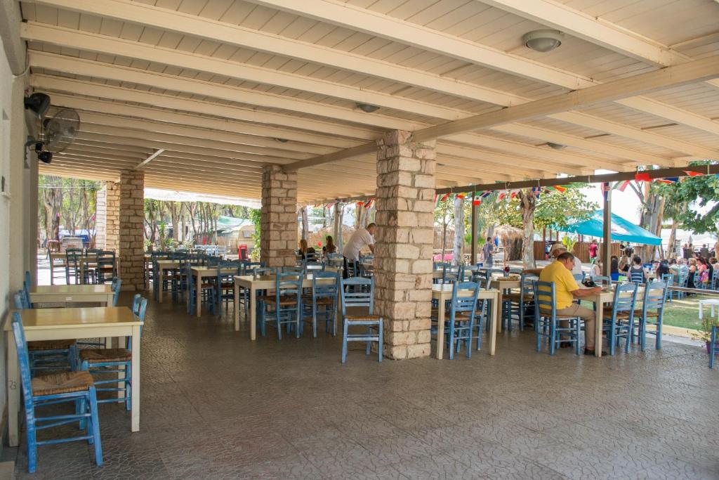 un ristorante con tavoli e sedie e persone sedute al loro interno di Camping Drepanos a Igoumenítsa