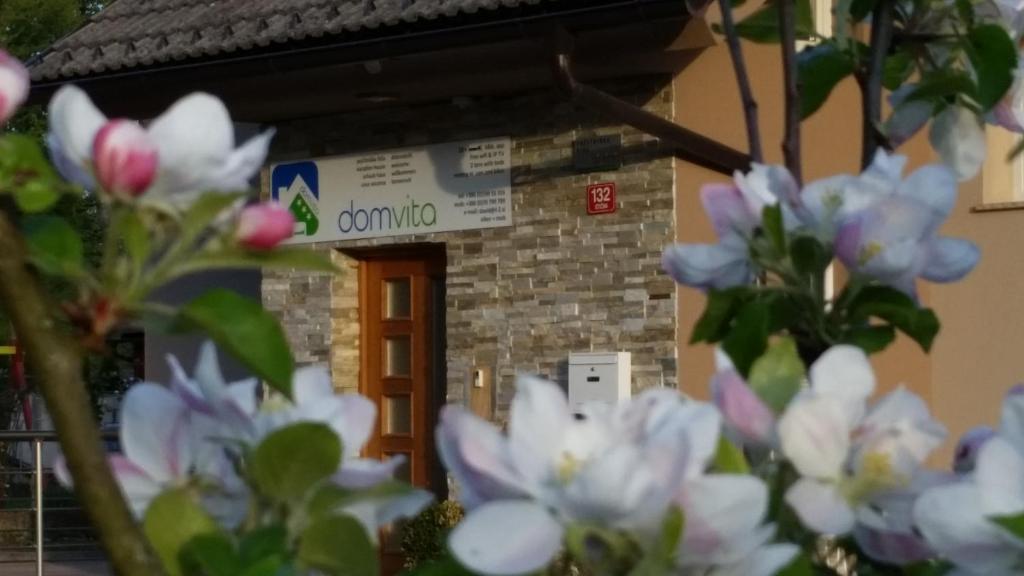 un edificio con fiori bianchi di fronte di Dom Vita Sticna a Ivančna Gorica