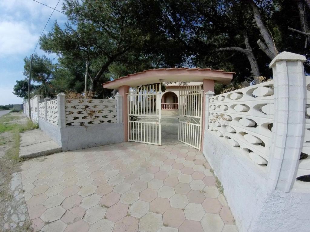 una recinzione bianca con un cancello su un patio di Villa Torretta - La casa di Luca a Marina di Lizzano