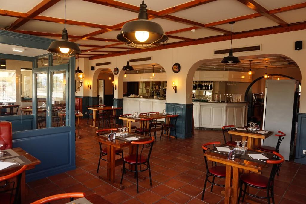 a restaurant with tables and chairs in a room at Le Bistrot D'orange in Orange