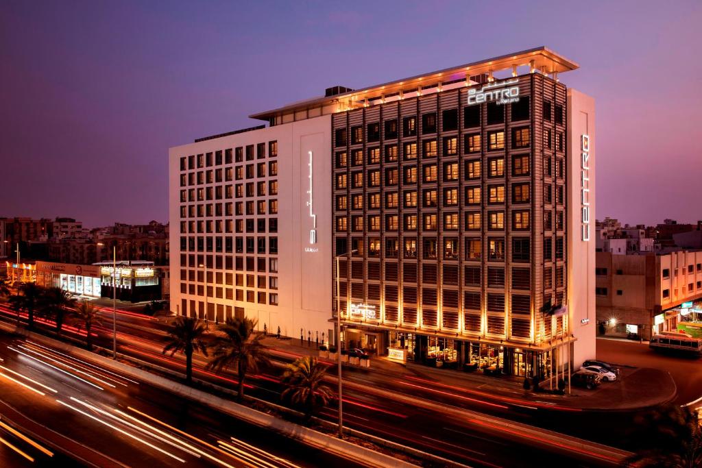 un grand bâtiment avec un panneau sur son côté dans l'établissement Centro Salama Jeddah by Rotana, à Djeddah