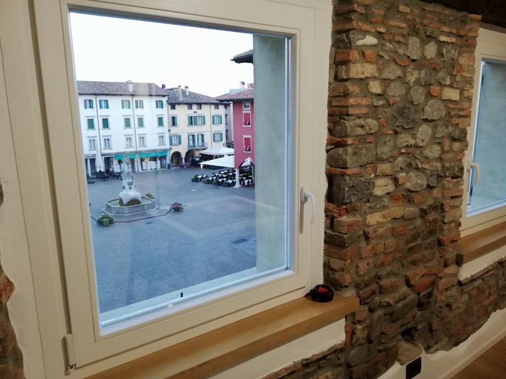 ein Fenster mit Blick auf einen Innenhof in der Unterkunft Casa In Piazza in Cividale del Friuli