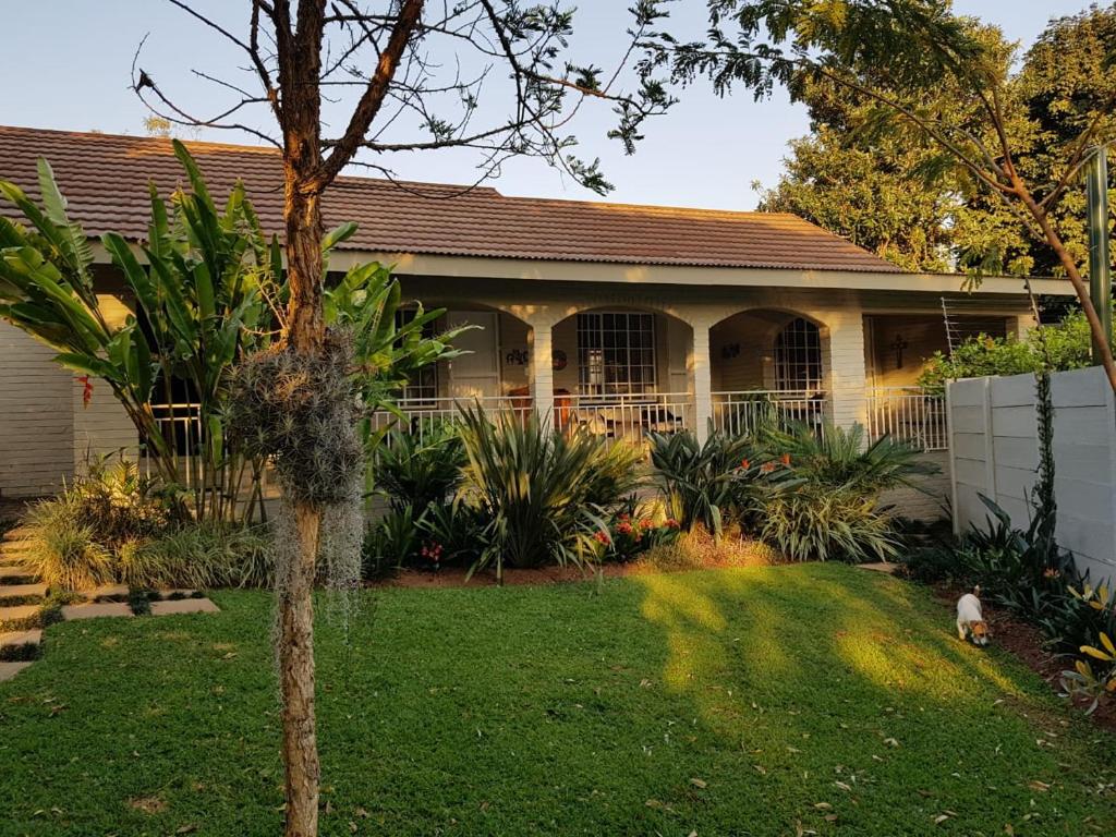 a house with a tree in the yard at JS Inn in Nelspruit