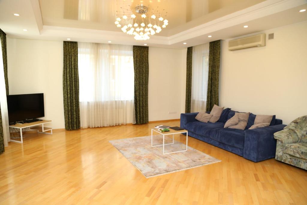 a living room with a blue couch and a television at Be My Guest - Apartments for trips in Kyiv