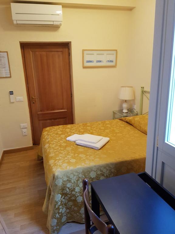 a room with two beds and a table and a window at Hotel Por Santa Maria in Florence