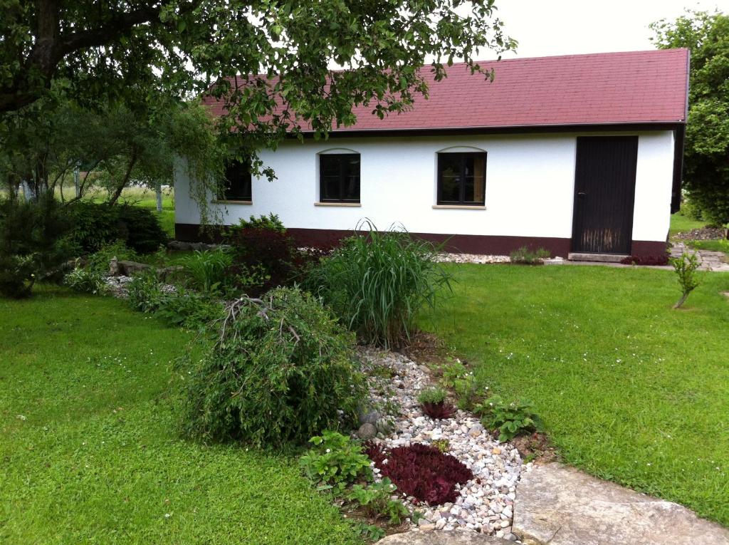 ein weißes Haus mit einem roten Dach und einem Hof in der Unterkunft U Kryštofa in Luže