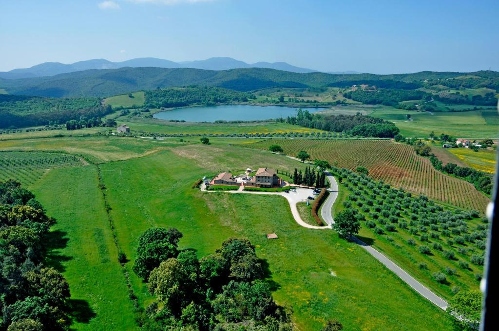 an aerial view of a farm with a lake at Agriturismo Il Felciaione in Massa Marittima