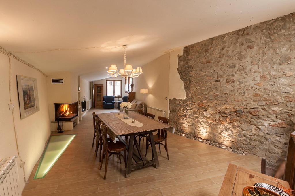 comedor con mesa y pared de piedra en Cal Martí, en Farena