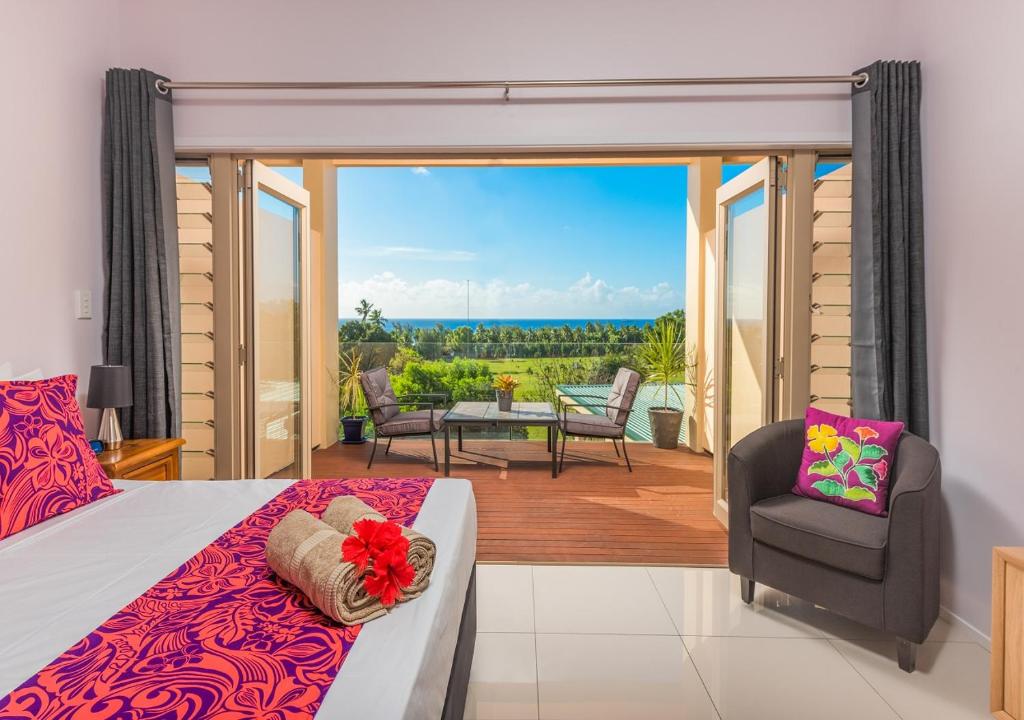 1 dormitorio con 1 cama y balcón con vistas. en Rarotonga GolfSeaView en Rarotonga