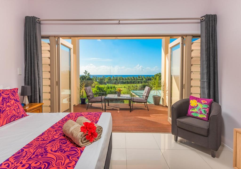 1 Schlafzimmer mit einem Bett und einem Balkon mit Aussicht in der Unterkunft Rarotonga GolfSeaView in Rarotonga