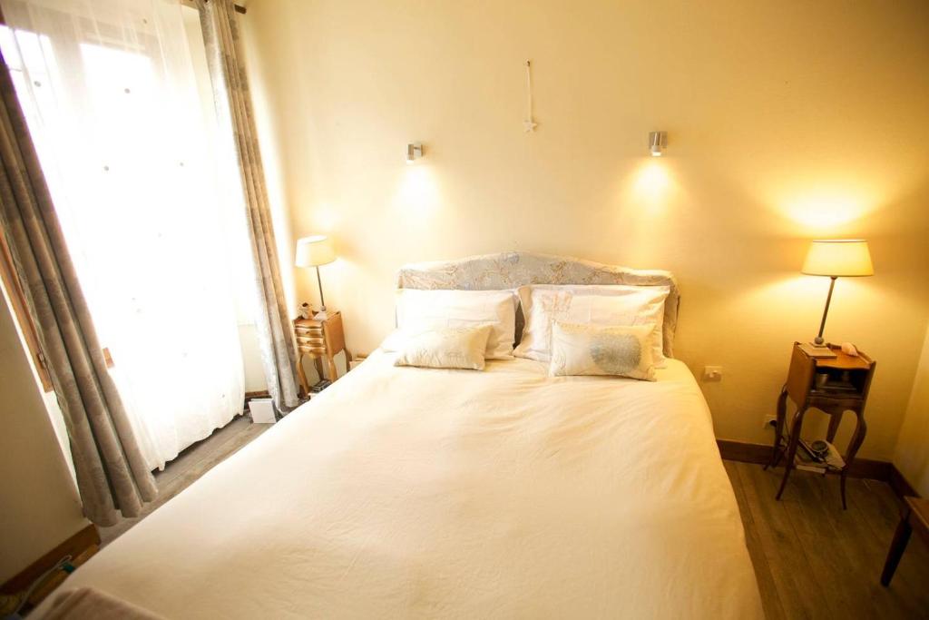 1 dormitorio con 1 cama blanca grande y ventana en Jolie maison avec jardin clos - Fontainebleau Héricy, 40 min Paris, en Héricy