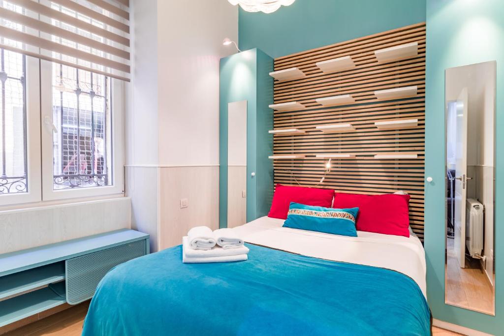 マドリードにあるPlaza del Callao IIのベッドルーム1室(大型ベッド1台、赤と青の枕付)